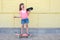 Happy girl listens to music while standing on a skateboard. Sport, fitness, lifestyle