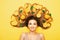 Happy girl lying with orange fruits on long hair, young surprised woman with citrus slices and leaves, concept energy and