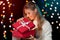 Happy girl opening Christmas box which is glowing inside. Christmas Gift