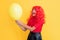 happy girl with party balloon on yellow background. wow