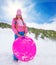 Happy girl in pink holding sled