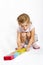 Happy girl playing with colourful wooden blocks