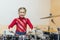 Happy girl playing the drums. Teen girls are having fun playing drum sets in music class. Girl in red drumming