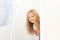 Happy girl playing hide and seek in wardrobe. Active child looking hiding behind a white door. A child with a happy face, playing