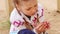 Happy girl plays with bright ladybug sitting on finger outdoor, closeup