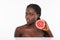 Happy girl with pomelo. Photo of african american girl holding a half of pomelo in front of her face and smiling on white