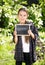 Happy girl posing in garden with blackboard with word