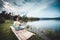 Happy girl pulling rod while fishing against landscape of lake.