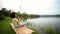 Happy girl pulling rod while fishing against landscape of lake.