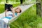 Happy girl reading in hammock in green park outdoors