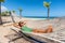 Happy girl relaxing on beach hammock in tropical vacation resort hotel. Holidays in the Caribbean tanning under the sun. Woman