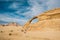 The happy girl on the rock and group of camels are in incredible beautiful landscape in desert