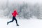 Happy girl running on snow in winter mountains. Sport, fitness inspiration and motivation. Young happy woman trail running in