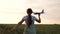 Happy girl runs with a toy plane on a wheat field. children play toy airplane. teenager dreams of flying and becoming a