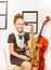 Happy girl in school dress with alto saxophone