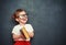 Happy girl schoolgirl with book from blackboard