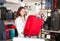 Happy girl in a shop, holding a travel suitcase