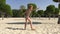 Happy girl showing acrobatic cartwheel on sand empty beach slow motion