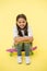 Happy girl sit on penny board on yellow background. Little child smile with long hair on skateboard. Beauty salon. Style