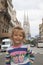 happy girl in sweater standing on street in European city of Vienna in summer