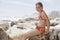 Happy Girl In Swimwear Sitting On Rock