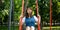 Happy girl on swing attractive and expressive emotion summer time concept portrait photography with blurred park outdoor