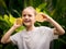 Happy girl with two halves of fresh lemon. Caucasian girl holding lemon, smiling and laughing. Selected focus. Green tropical