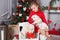 Happy girl with two puppies Golden Retriever on a background of Christmas tree