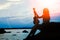 Happy girl with ukulele by the sea on nature silhouette background