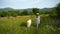 Happy girl walks dog in daisy field. Countryside Outdoor walk with pet. Dressed in a blue dress and a straw hat.