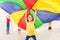 Happy girl waving parachute during sports festival