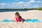 Happy girl on a yoga Mat doing gymnastics on the beach. Active life style. The concept of sport and active play in the summer