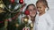 Happy girls, mother and daughter decorating a Christmas tree at home.