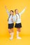 Happy girls in school uniform. smart little girls on yellow background. education concept. back to school. kid fashion