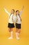 Happy girls in school uniform. smart little girls on yellow background. education concept. back to school. kid fashion