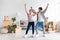 Happy glad millennial european lady and guy in casual dancing, enjoy relocation in room