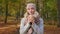 Happy, glad woman standing in park, holding paper cup.