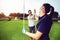 Happy golf player couple giving high five while standing on field