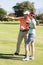 Happy golfer man pointing while standing by woman