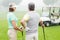 Happy golfing couple with golf buggy behind