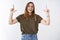 Happy good-looking charismatic young caucasian female tomboy model wearing olive t-shirt jeans smiling laughing casually