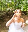 Happy gorgeous bride have fun with bubble blower outdoors in park