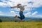 Happy gorgeous girl enjoy mountain view jumping on the hill with breathtaking mountain landscape