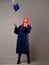 Happy graduate on a gray background. A young woman with bright hair.