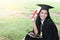 Happy graduate young Asian woman in cap and gown holding a certificated in hand, A diploma with red ribbon education concept in