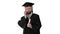 Happy graduated young man in cap and gown talking with a friend on mobile phone on white background.