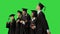 Happy graduation students performing a funny dance on a Green Screen, Chroma Key.