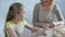 Happy granddaughter cooking with granny, giving her high five, homemade pastry