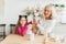 Happy granddaughter and grandmother in the kitchen with jack russell terrier dog. Grandma and grandchild spend time