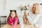 Happy granddaughter and grandmother in the kitchen with jack russell terrier dog. Grandma and grandchild spend time